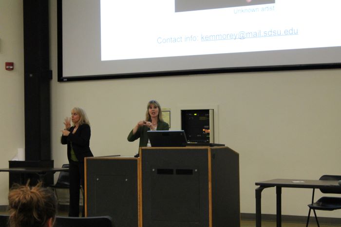 Dr. Karen Emmorey and Sign Language translator giving a lecture.