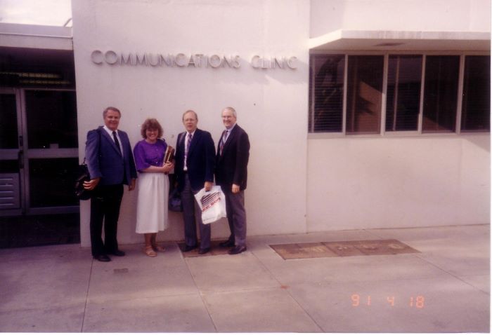Four Professional Colleagues in front of Communications Clinic Building